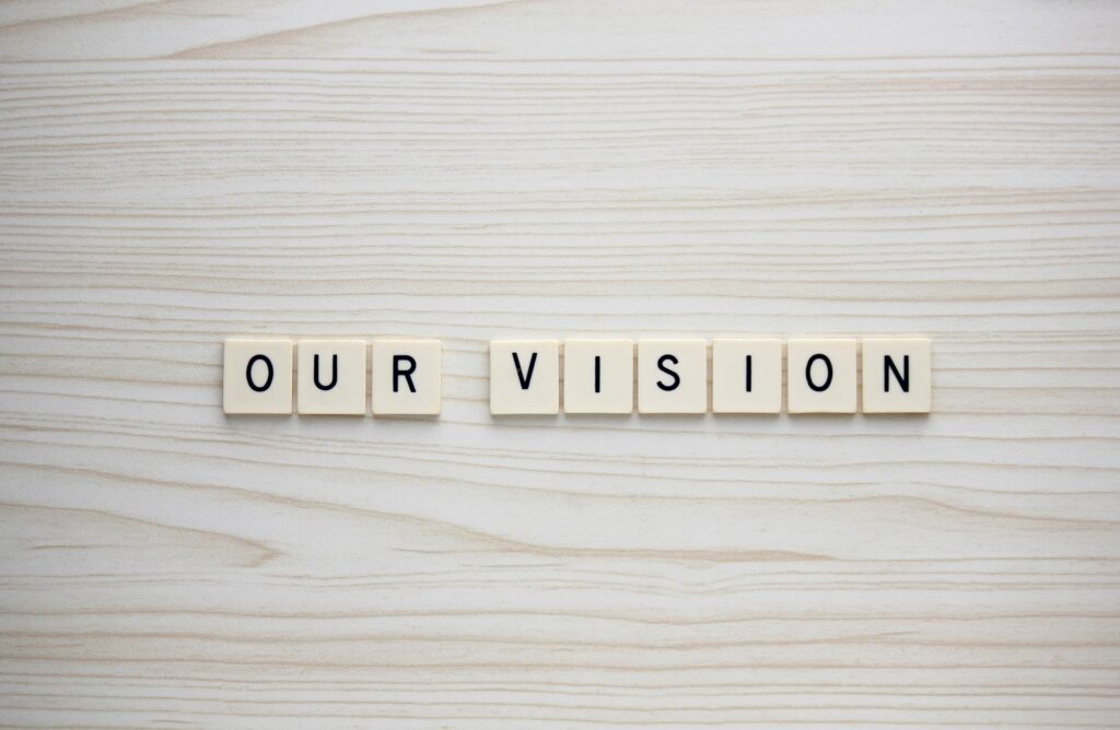 Our Vision letter tiles on a wood grain background